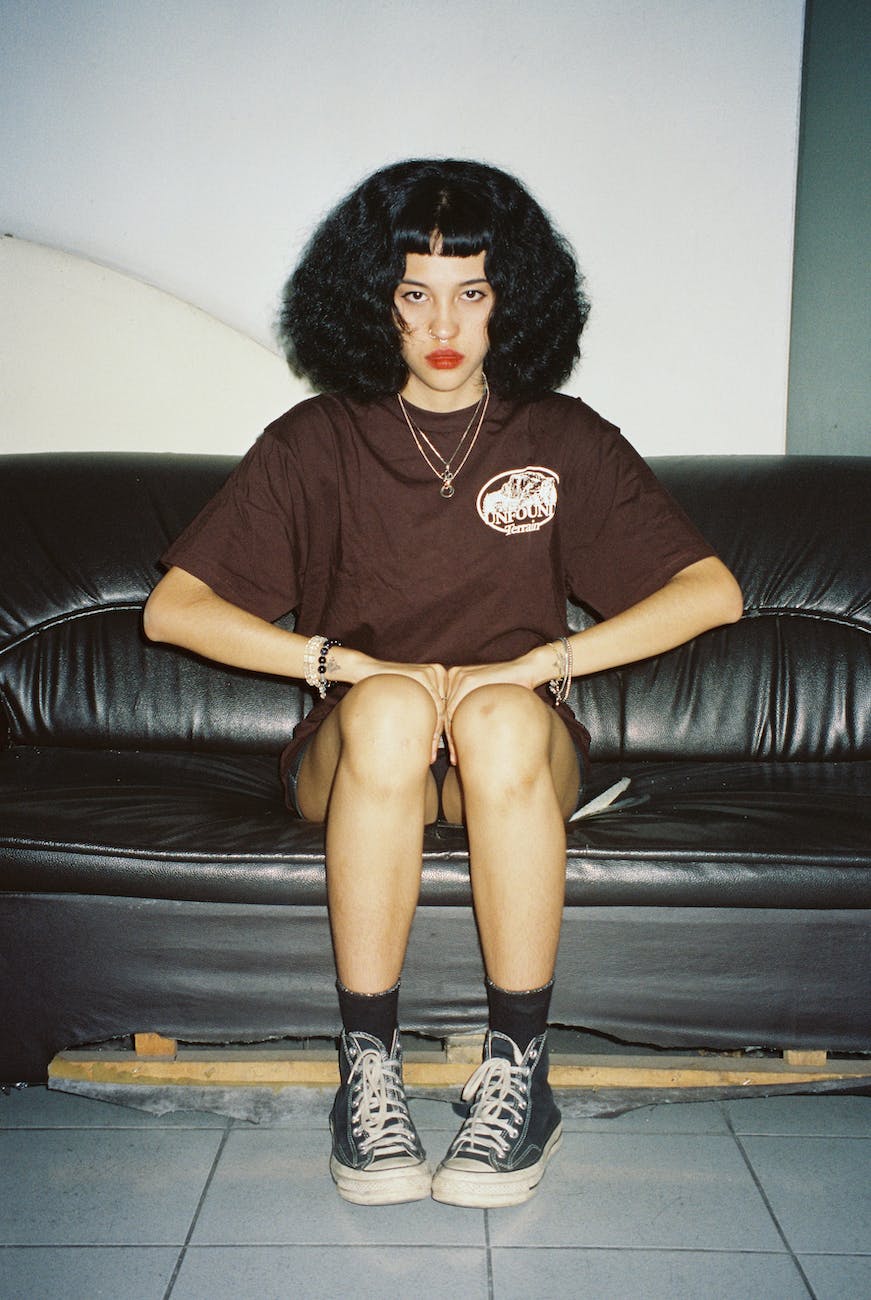 photo of a young woman sitting on the black couch